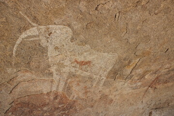 Ancient african cave painting on a rock of an elephant and herd of animals on a sloped wall