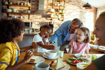 Young mixed family eating together at home - Powered by Adobe