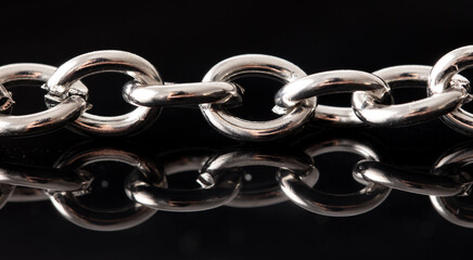 Silver chain with reflection on a black background