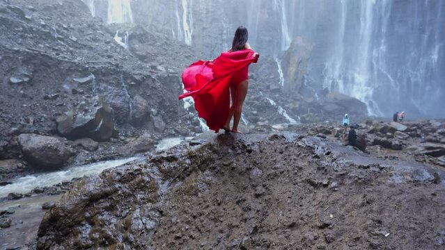 4k slow motion video. Tumpak Sewu in East Java, Indonesia with young woman in red dress, Video Shot