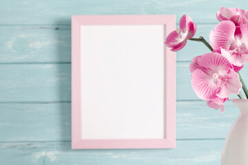 Beautiful flowers composition. Photo frame, orchid flower on pastel turquoise background. Valentines Day, Happy Women's Day. 