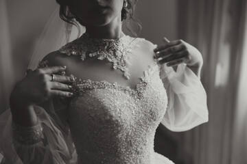 The bride's wedding dress with sleeves. The dress is embroidered with beads and the sleeves are...