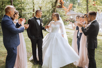 full-length portrait of the newlyweds and their friends at the wedding. The bride and groom with...
