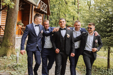 Cheerful, young, energetic witnesses of the groom next to the groom. Friends congratulate the...