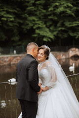 Naklejka premium Wedding. Love and couple in garden for wedding. Celebrating the ceremony and commitment. Save the date. Trust. The groom embraces the bride. Tender kisses. Couple in love. Wedding portrait
