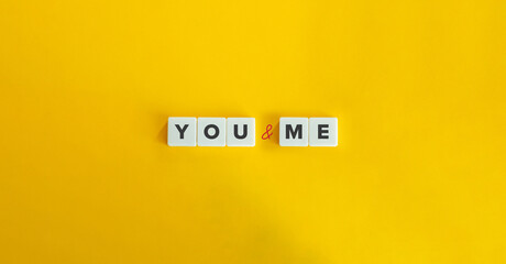 You and Me Text on Block Letter Tiles on Yellow Background. Minimalist Aesthetics.