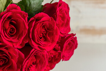 Bouquet of red roses on wooden table. Greeting card for Valentines Day, Womens Day. Holiday concept.