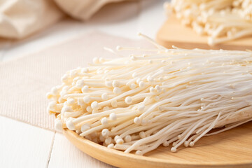Fresh golden needle mushroom or enoki, enokitake (Flammulina velutipes) in wooden plate