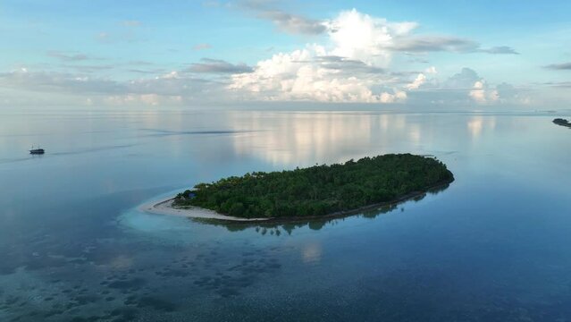 A serene sunrise illuminates the remote island of Koon near Seram, Indonesia. This scenic island's coral reefs, and the surrounding seas, support extraordinary marine biodiversity.