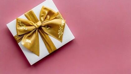 blank gift card with golden bow on pink background top view space for text