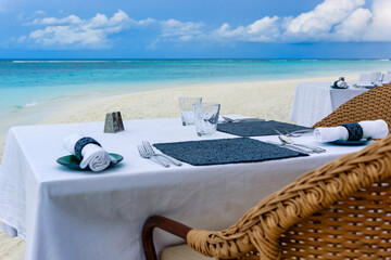 Romantic table setting for two on the beach in front of turquoise ocean