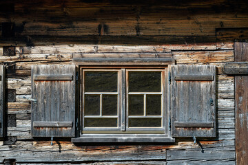 Facade and window with shutters of old wooden farmhouse