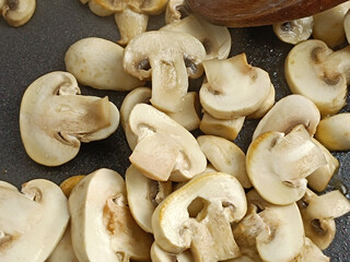 champignons de Paris cuisant dans une poêle	
