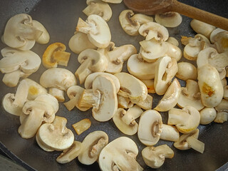 champignons de Paris cuisant dans une poêle	