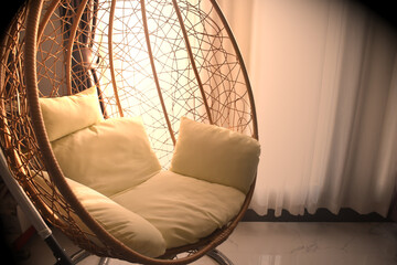 Teardrop-shaped swing chairs decorate the interior, a warm atmosphere, and loneliness set the scene.