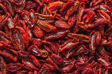 Sun dried red tomato, top view, closeup. Background and texture of dried red tomatoes