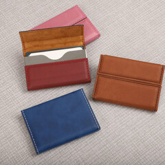 Colored leather business card holder, Genuine leather business card holder, concept shot, top view, different color, clamshell and stitched card holder. Gray background.