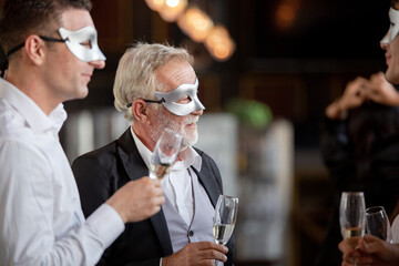 Group of office worker in fancy mask having celebration party. people cheers toasting wine glasses...