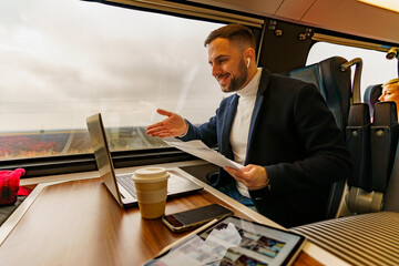 Businessman commuting by train, talking for a video call via laptop,discusses new project ideas