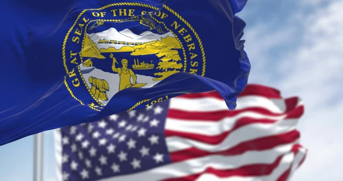Nebraska state flag waving with the American flag in background