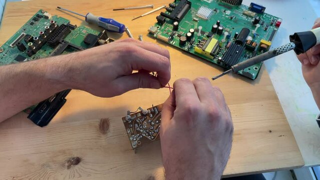 Close up Soldering a micro chip processor with iron tool on a green circuit boad. Electroncs service technology and macro computer concept background.
