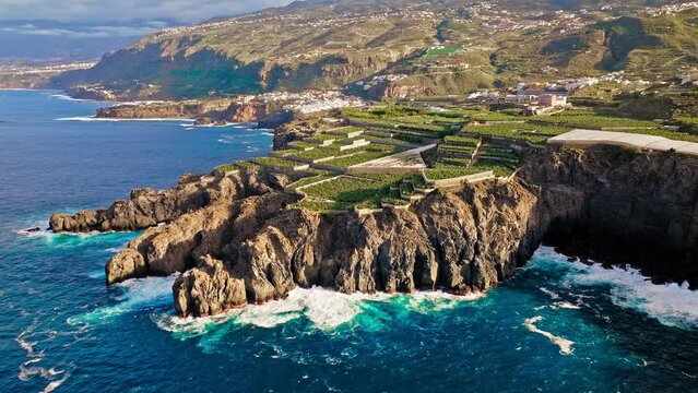 Aerial view of a large volcanic rock and a swimming pool by the cliffs in Tenerife, Spain. View from above of Charco De La Laja coastal pool formed by erosion and filled with seawater at high tide.
