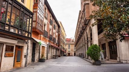 Picturesque street in the city of Valladolid with arcades in historic buildings, Spain. - obrazy, fototapety, plakaty