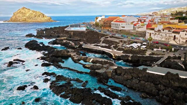 Aerial view of Piscinas Naturales de El Calet&oacute;n of Garachico and colourful houses in Tenerife. Series of natural, rocky swimming pools on the coast, with sunbathing areas and steps to the water,Spain.