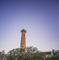 Ancient brick minaret in the evening in the ancient city of Fort Khiva in Khorezm, medieval...