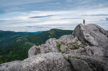 Trail runner over the horizon, standing at the top of Morios mountain of a summer day, Charlevois, QC, Canada