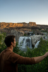 Man looking at Shoshone Falls at Sunrise in Twin Falls, Idaho  Also called Niagara Falls of the west.  Shot on a mirrorless camera.  Beautiful waterfall.