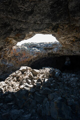 Craters of the Moon National Monument and Preserve, Idaho.  This cave is located in Idaho, United States.   Beautiful open top cave with the sun shining into the cave.  Shot on a mirrorless camera.