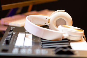 white headphone on synthesizer keyboard. recording concept. music background