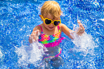 Child near the pool in sunglasses. Selective focus.