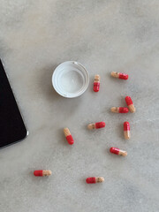 pills spread out on white desk adderall 30mg addiction bottle in home office