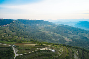Panoramic aerial view of the mountainous countryside with terraced vineyards on the slope. Shot from a drone.