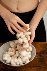 Preparing fresh vegetables: white mushrooms ready for the pan.