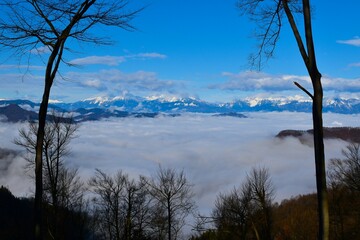 View of fog covered Gorenjska, Slovenia with snow covered mountains in the background