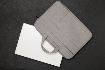 Grey stylish laptop bag with device on concrete background,top view