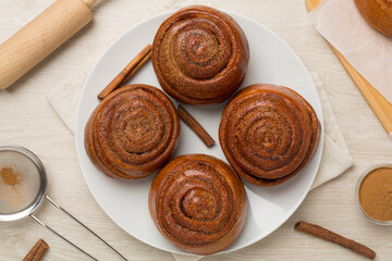 Sweet homemade cinnamon rolls on wooden background, top view
