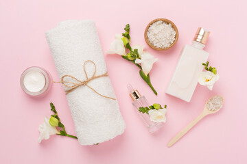 Flat lay with spa products and flowers on color background