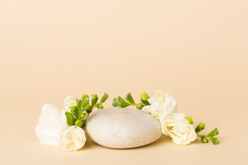 Stone podium with freesia flower on color background. Mock up for cosmetic products