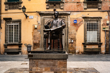 LUCCA, ITALY, APRIL 16, 2017: Detail of a bronze statue of Giacomo Puccini, famous Italian opera composer, in downtown of Lucca his hometown. Tuscany, Italy, Europe. - obrazy, fototapety, plakaty