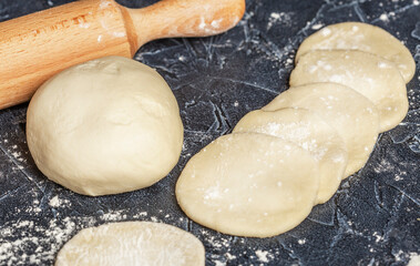 ball of fresh raw dough, flour and rolling pin top view