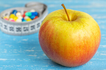 Diet for weight loss apples or pills with measuring tape