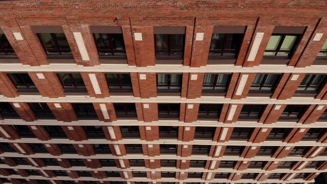 Exterior of a brick building with windows, aerial shot. Facade of a brick multistory building with windows. Red brick wall. Top view