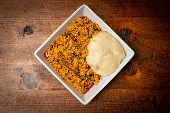Nigerian egusi soup with meats, vegetables and cassava dough