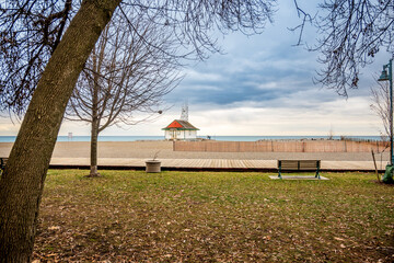Wooden boardwalk in the Toronto beaches with a red wooden snow fence and a white lifeguard station...