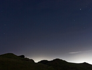 Northumberland night sky over Northumberlandia with stars, cloud and light pollution.