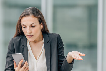 business woman with mobile phone and expression of incomprehension or resignation